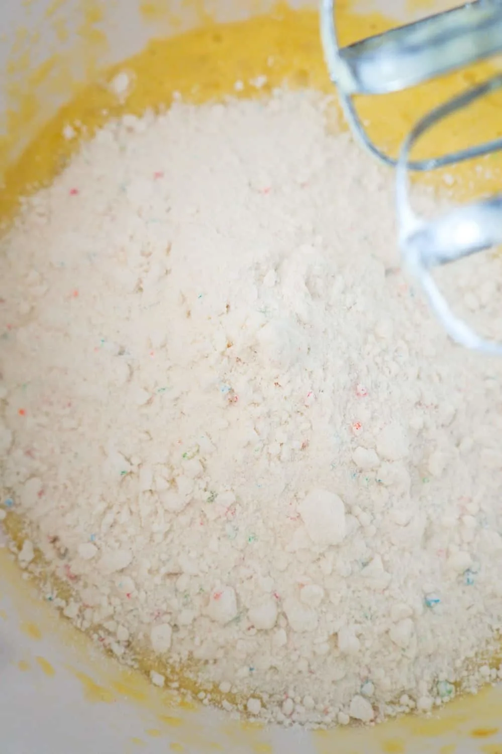 confetti cake mix added to banana and egg mixture in mixing bowl