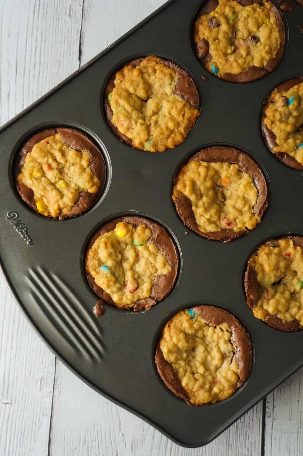 Monster Cookie Brownie Cups are an easy dessert recipe using boxed brownie mix and homemade oatmeal peanut butter cookie dough. These chewy brownie cups are loaded with mini M&Ms.