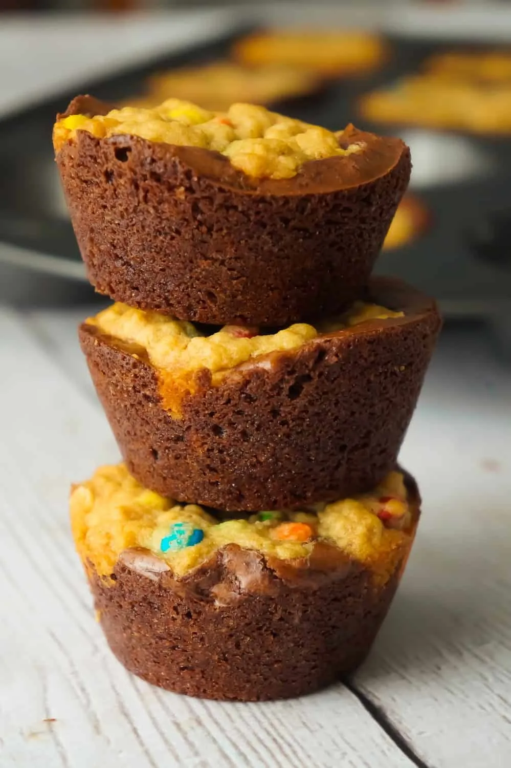 Monster Cookie Brownie Cups are an easy dessert recipe using boxed brownie mix and homemade oatmeal peanut butter cookie dough. These chewy brownie cups are loaded with mini M&Ms.