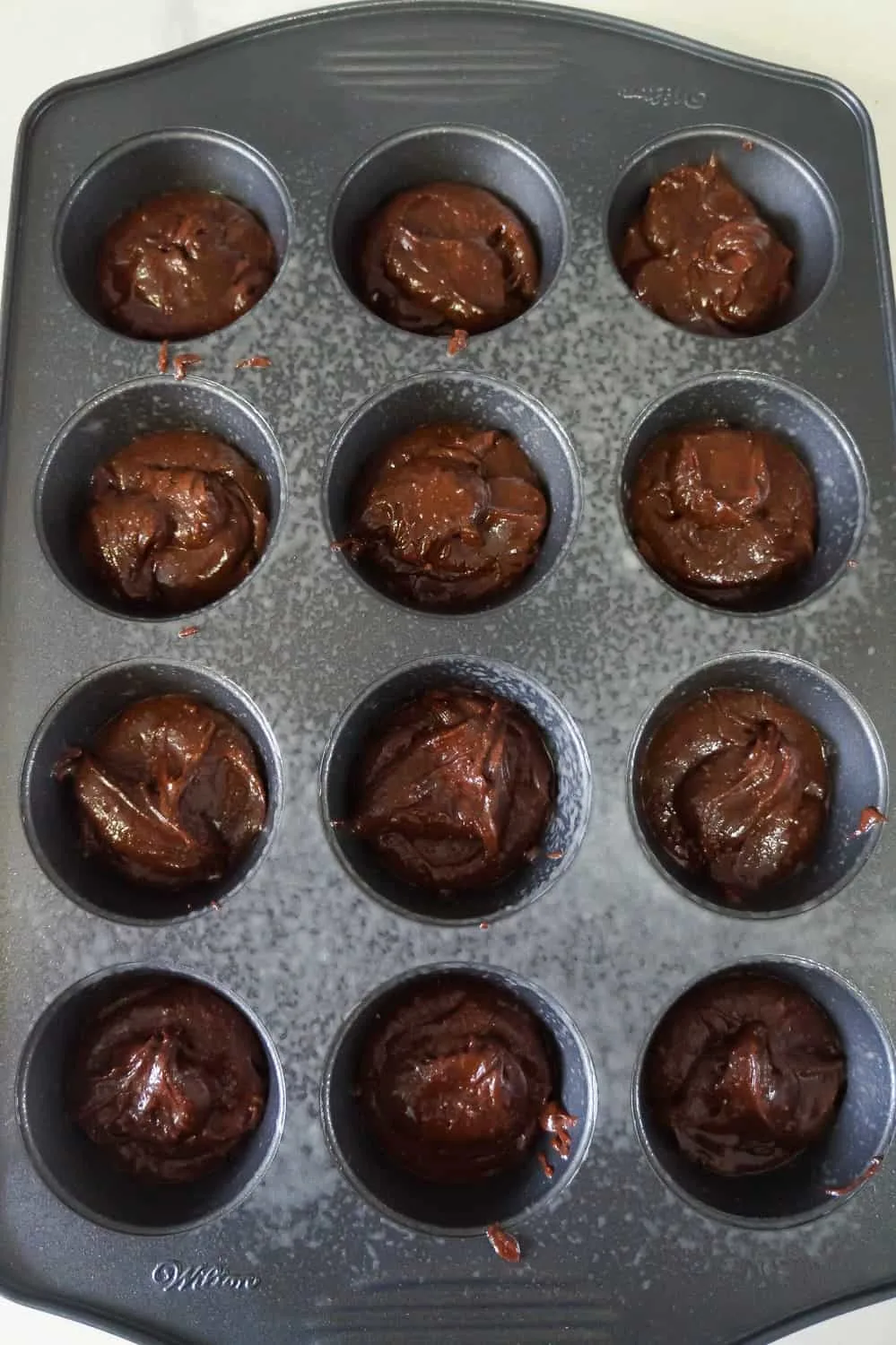 brownie batter in muffin tins