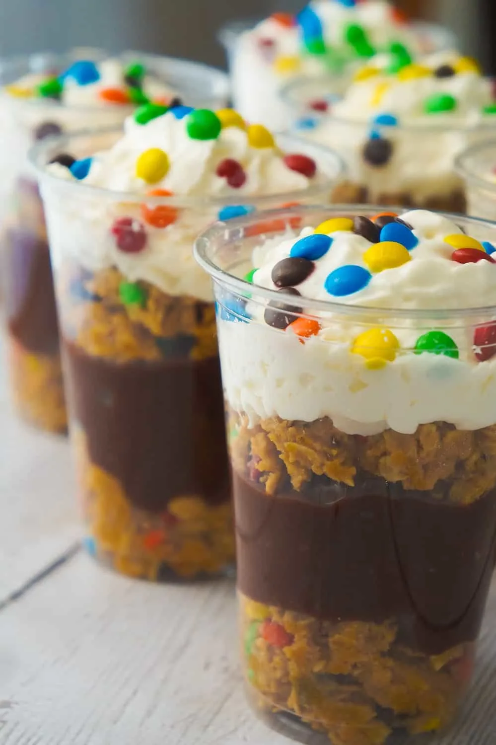 Monster Cookie Pudding Parfaits are a fun and easy no bake dessert perfect for summer. These colourful dessert cups are loaded with oatmeal peanut butter cookie dough, chocolate pudding and mini M&Ms.