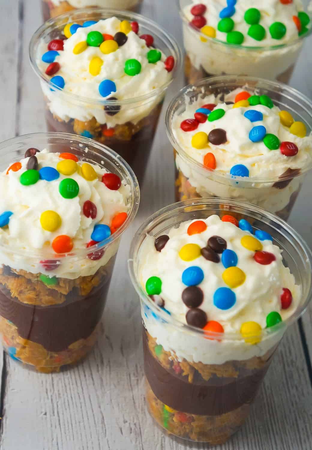 Monster Cookie Pudding Parfaits are a fun and easy no bake dessert perfect for summer. These colourful dessert cups are loaded with oatmeal peanut butter cookie dough, chocolate pudding and mini M&Ms.