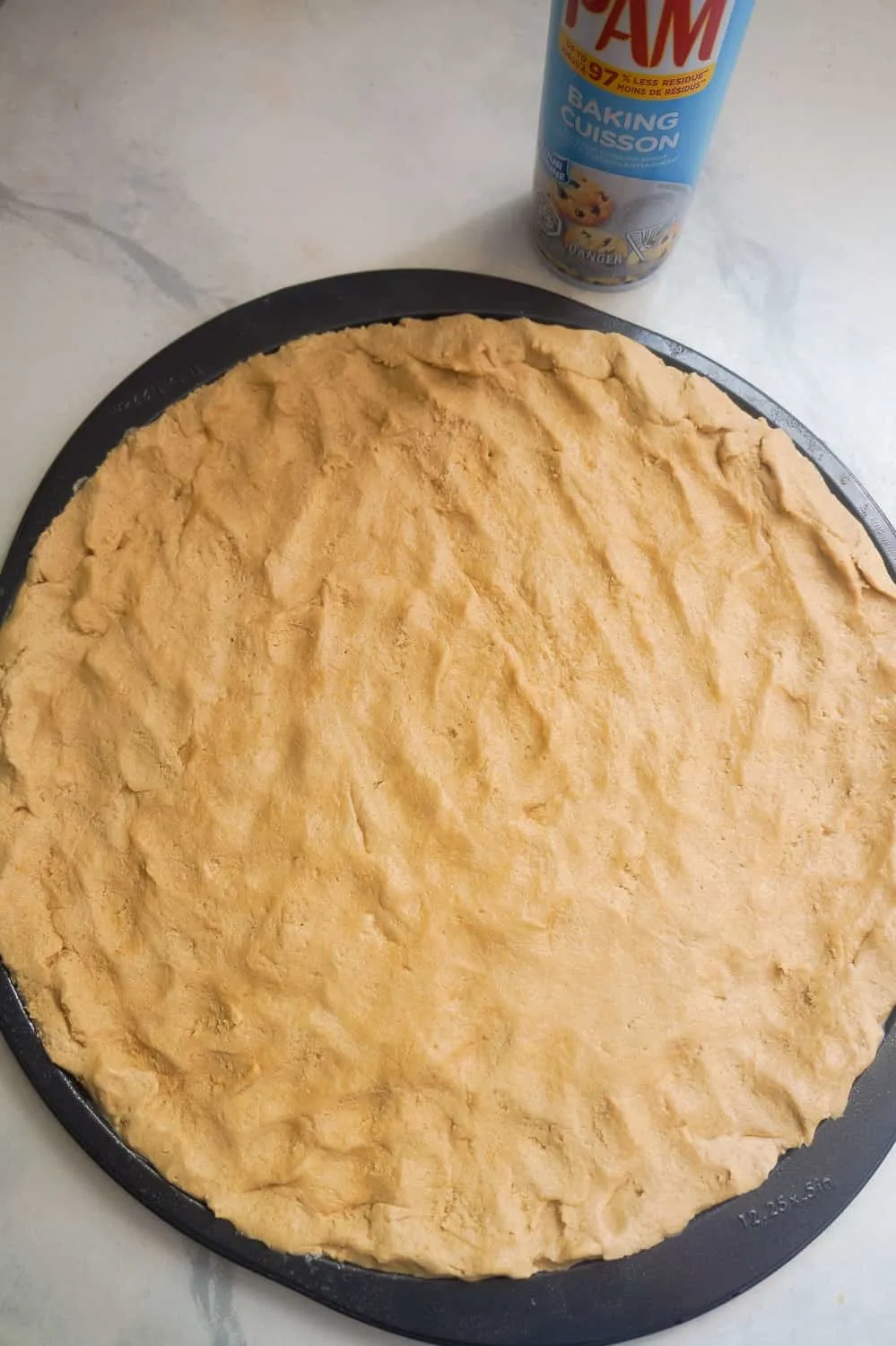 peanut butter cookie dough pressed into round baking pan