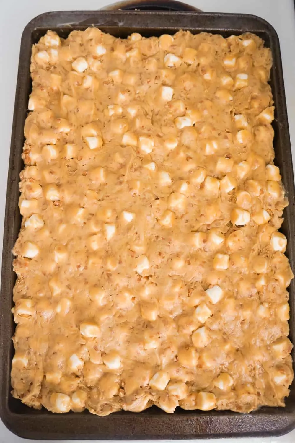 peanut butter marshmallow cookie dough spread out on baking sheet