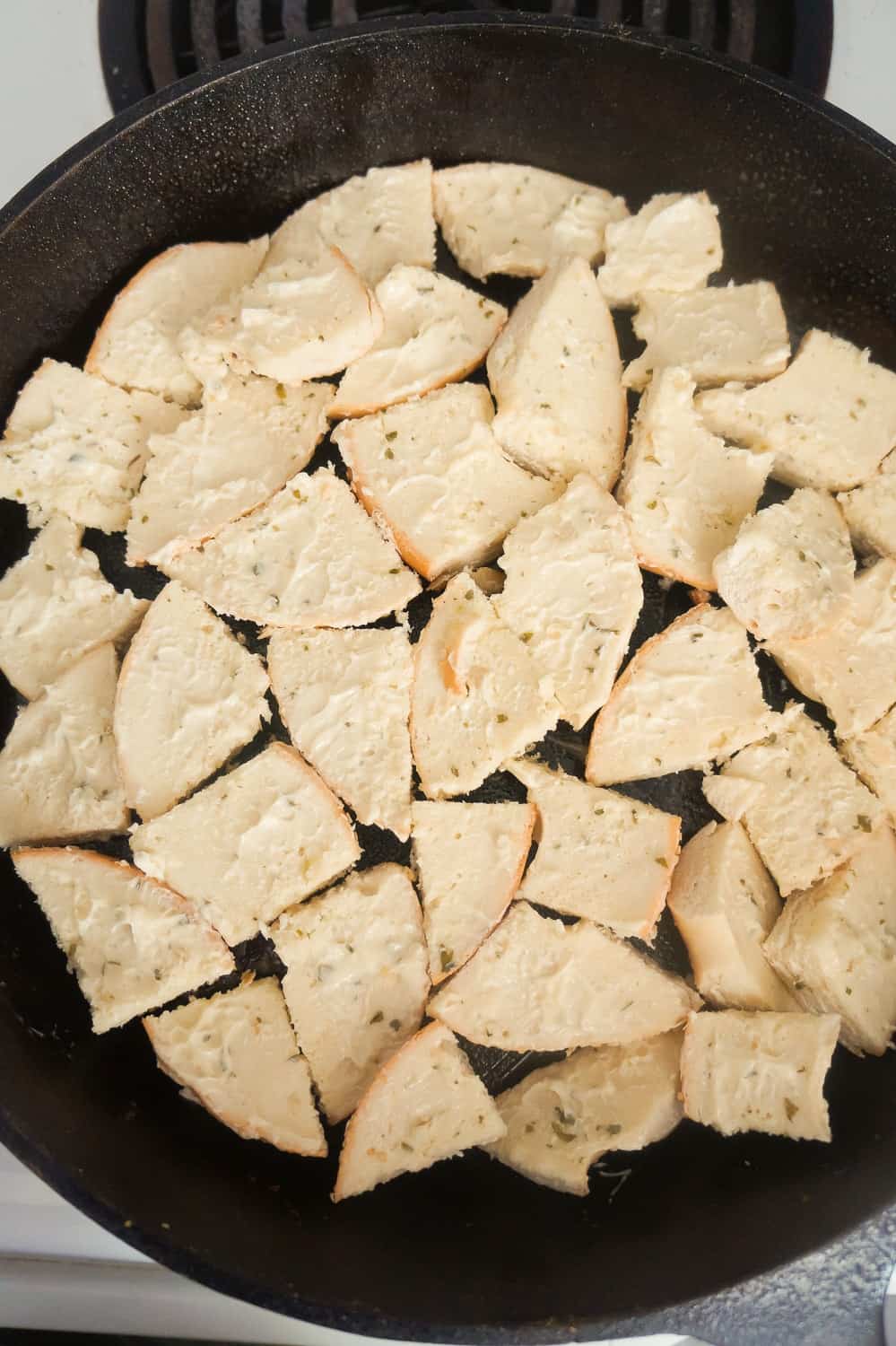 bagel pieces in the bottom of a cast iron skillet