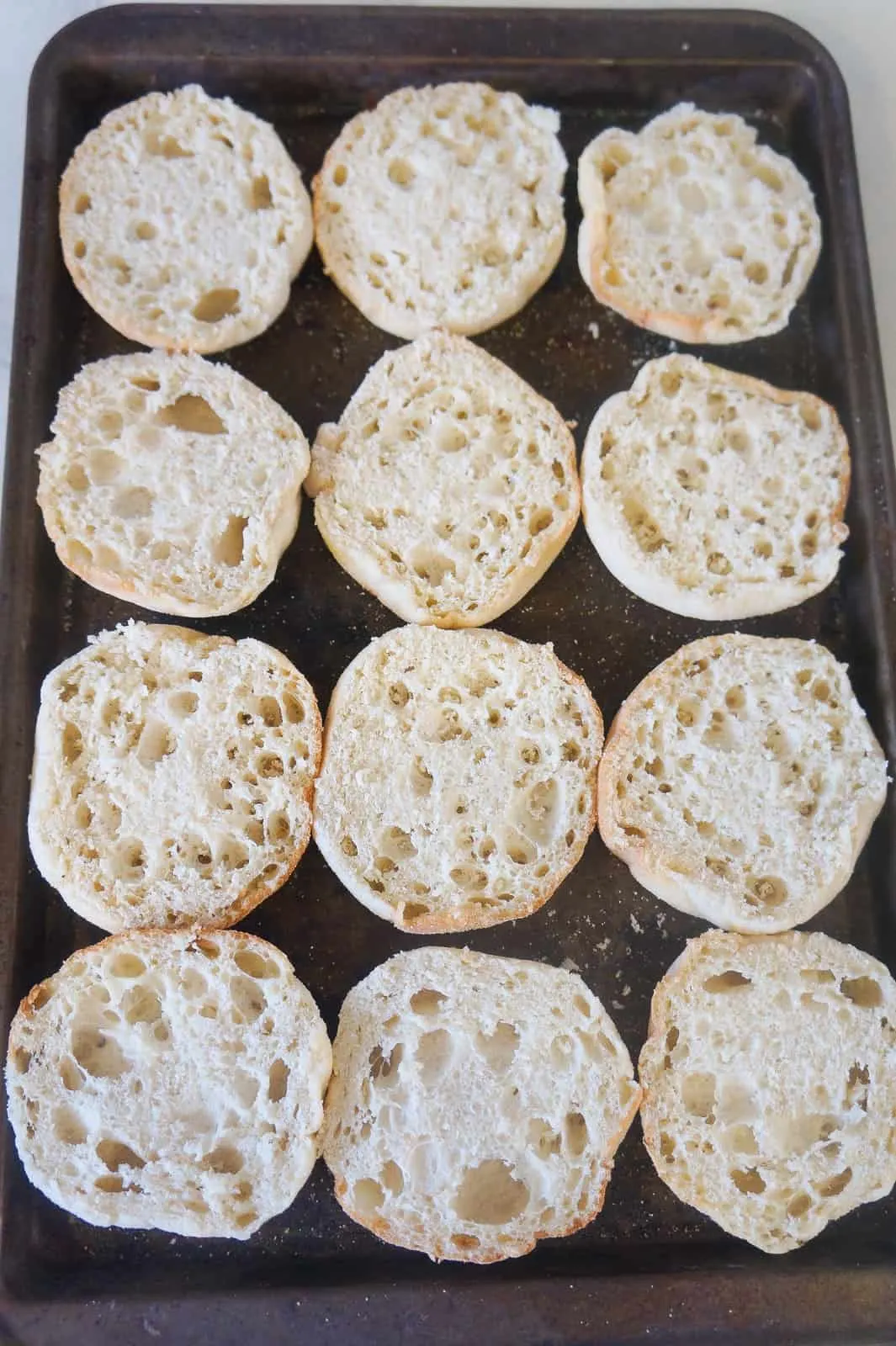 sliced english muffins on baking sheet