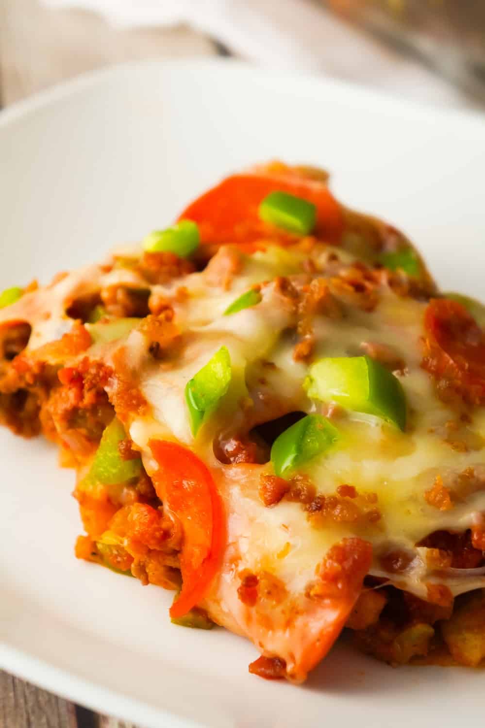 Pizza Frito Pie is an easy ground beef dinner recipe. This fun twist on the classic Frito pie is loaded with pepperoni, green peppers and bacon.