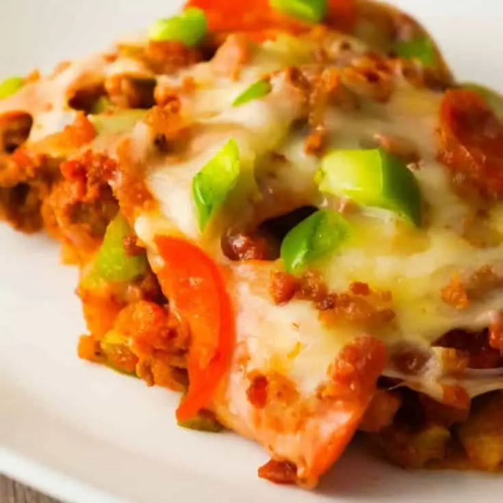 Pizza Frito Pie is an easy ground beef dinner recipe. This fun twist on the classic Frito pie is loaded with pepperoni, green peppers and bacon.