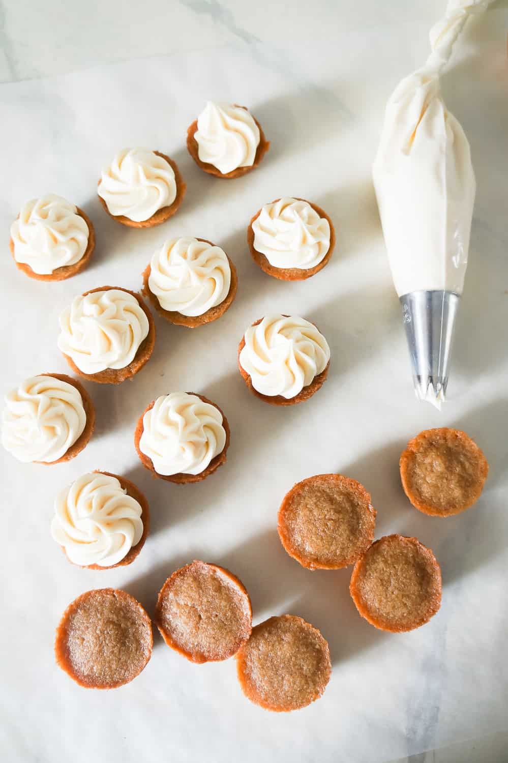 piping bag with cream cheese frosting next to pumpkin spice blondie bites