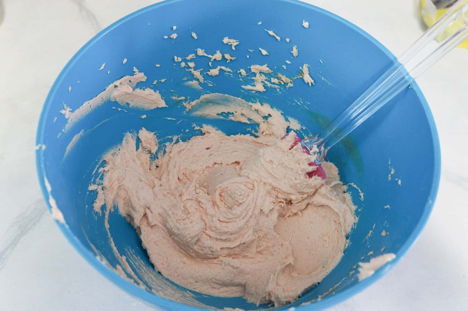 peanut butter cream cheese mixture in a blue mixing bowl
