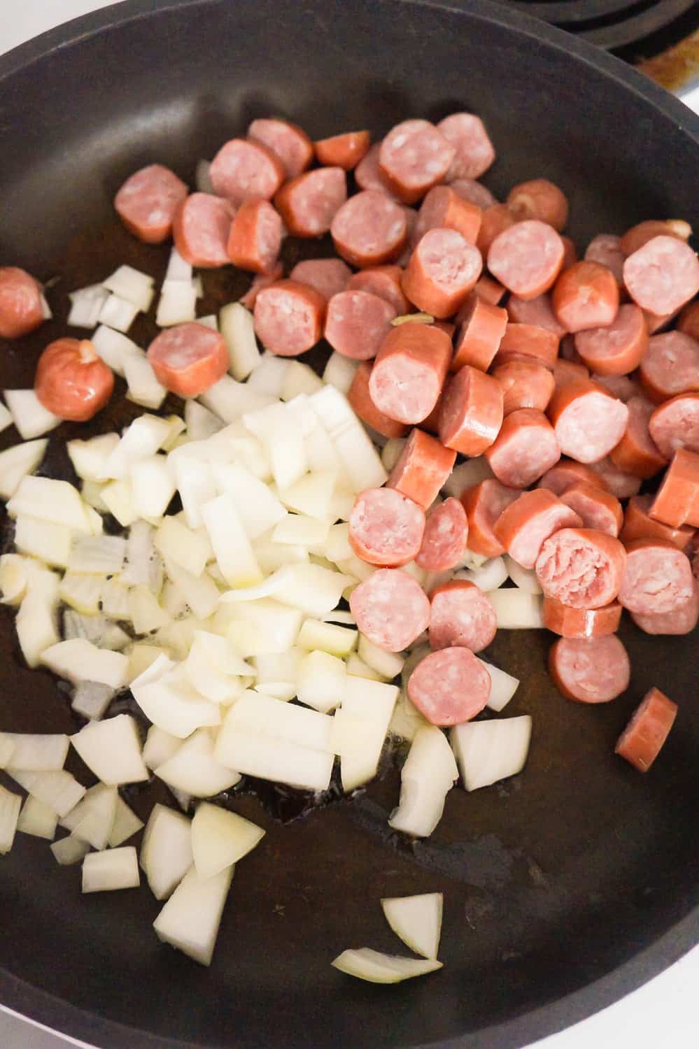 diced onions and chopped breakfast sausage in a frying pan