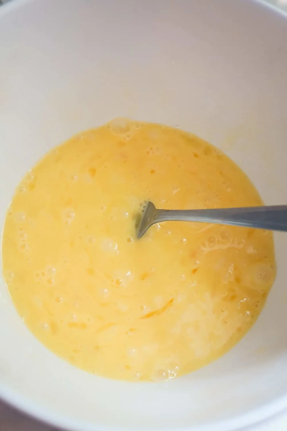 beaten eggs in a mixing bowl with a fork