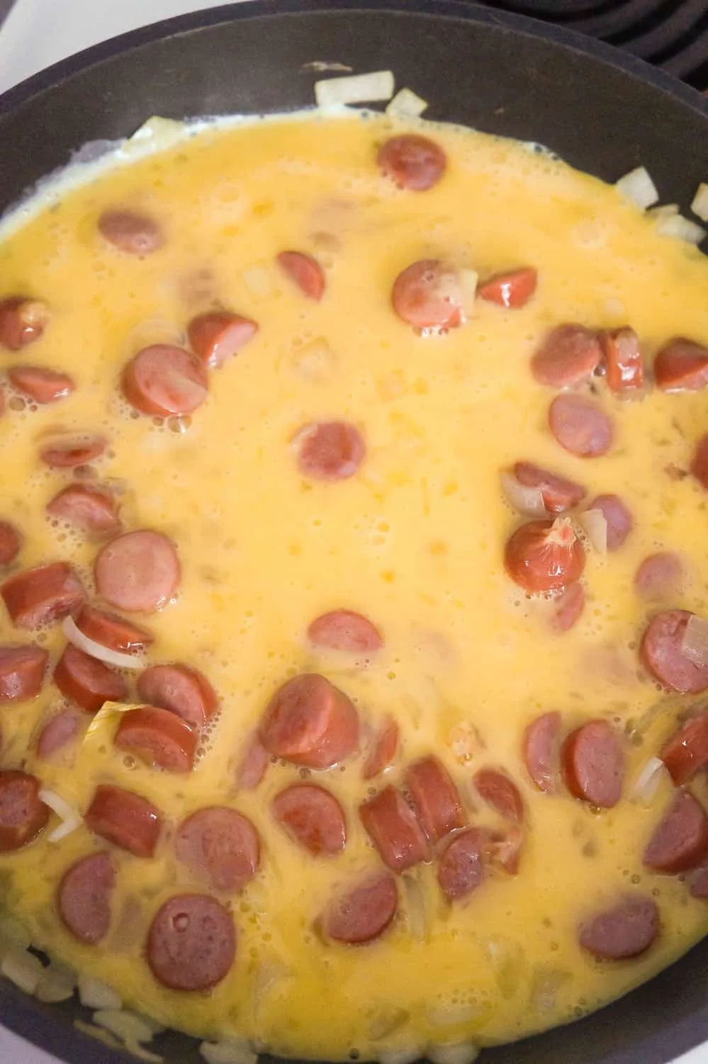 beaten egg in a frying pan with chopped breakfast sausage