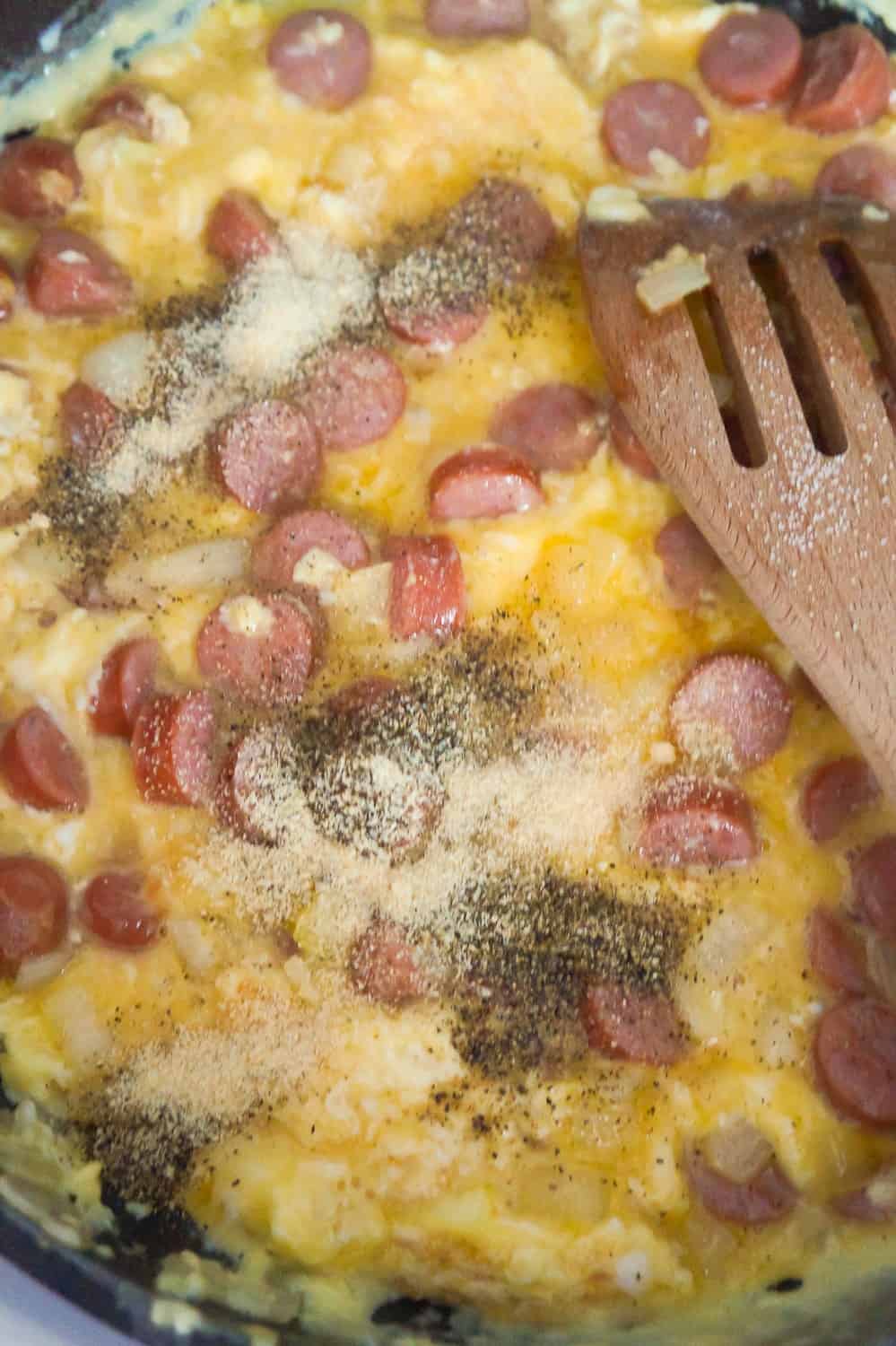 salt and pepper on top of egg cooking in frying pan