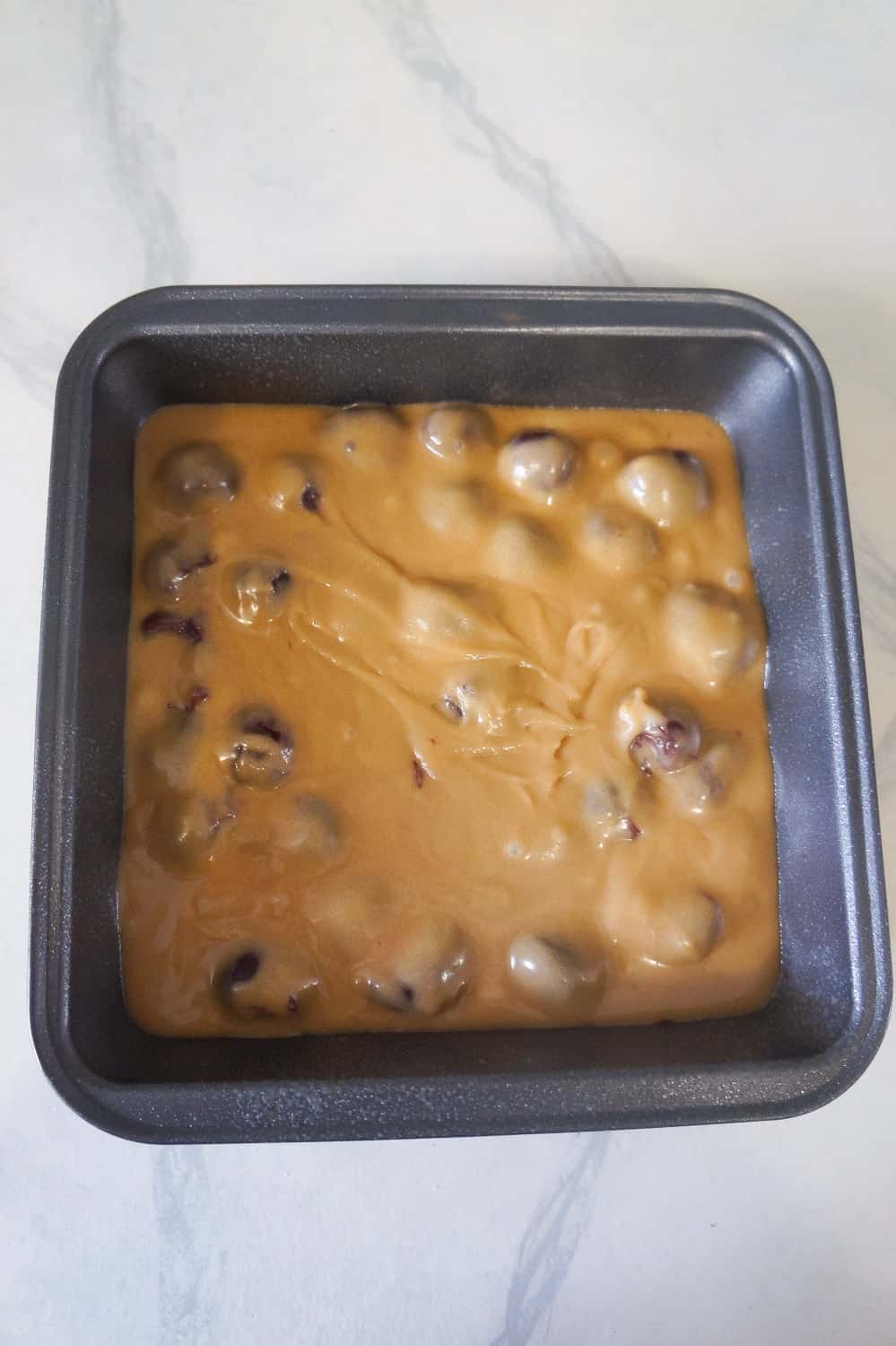 sour cherry blondie batter in a baking pan