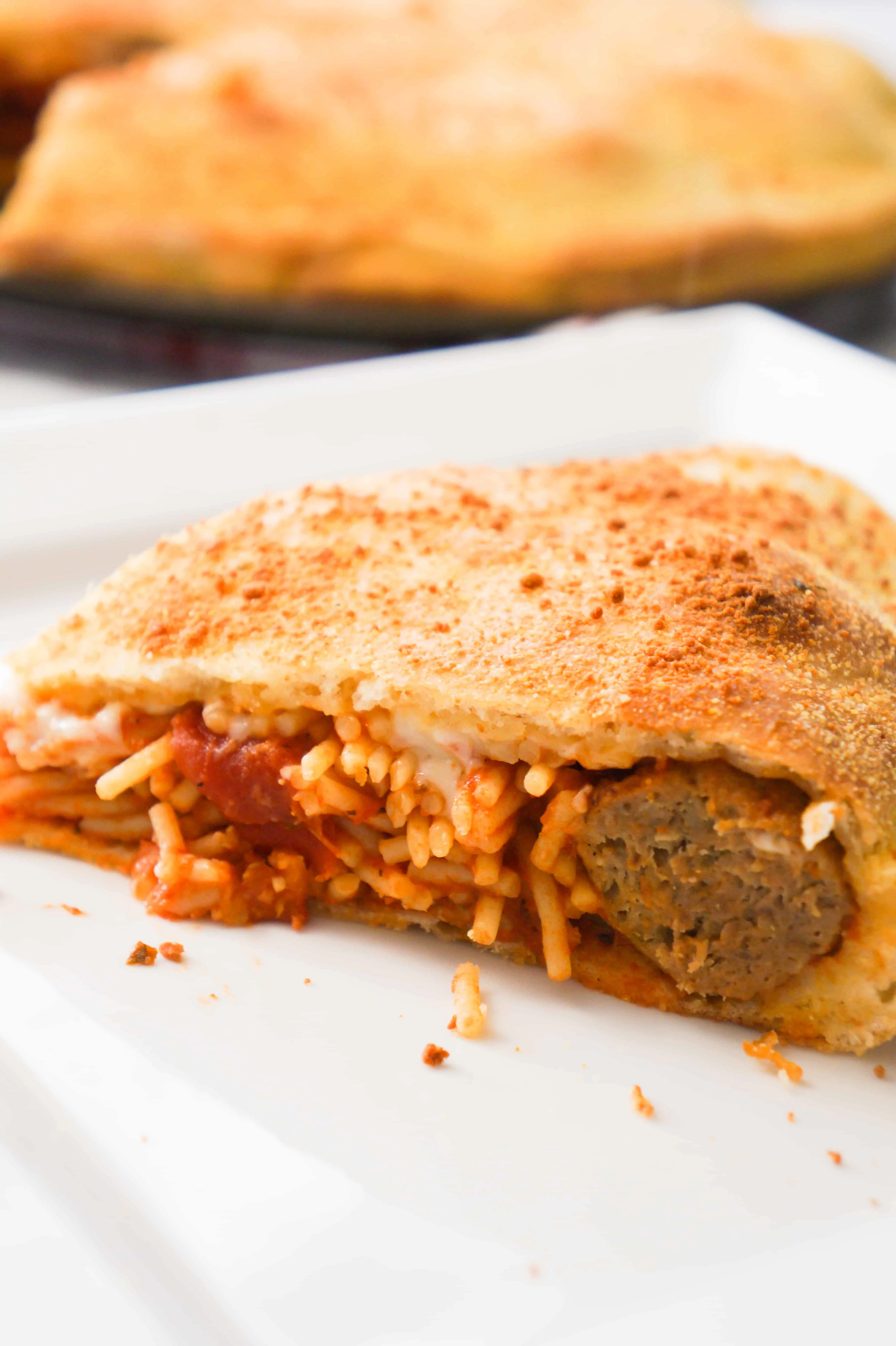 Plate with spaghetti and meatballs pizza slice