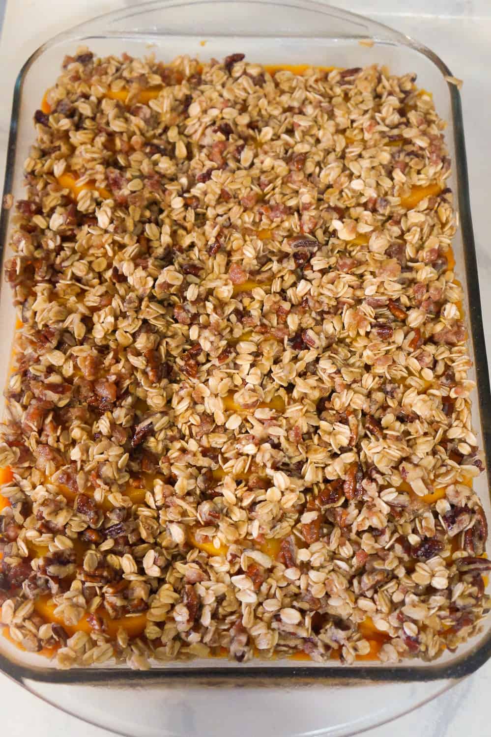Sweet Potato Casserole with Peaches, Pecans & Bacon is the perfect side dish for a holiday dinner. Creamy mashed sweet potatoes are topped with sliced peaches and an oat crumble with pecans and bacon.