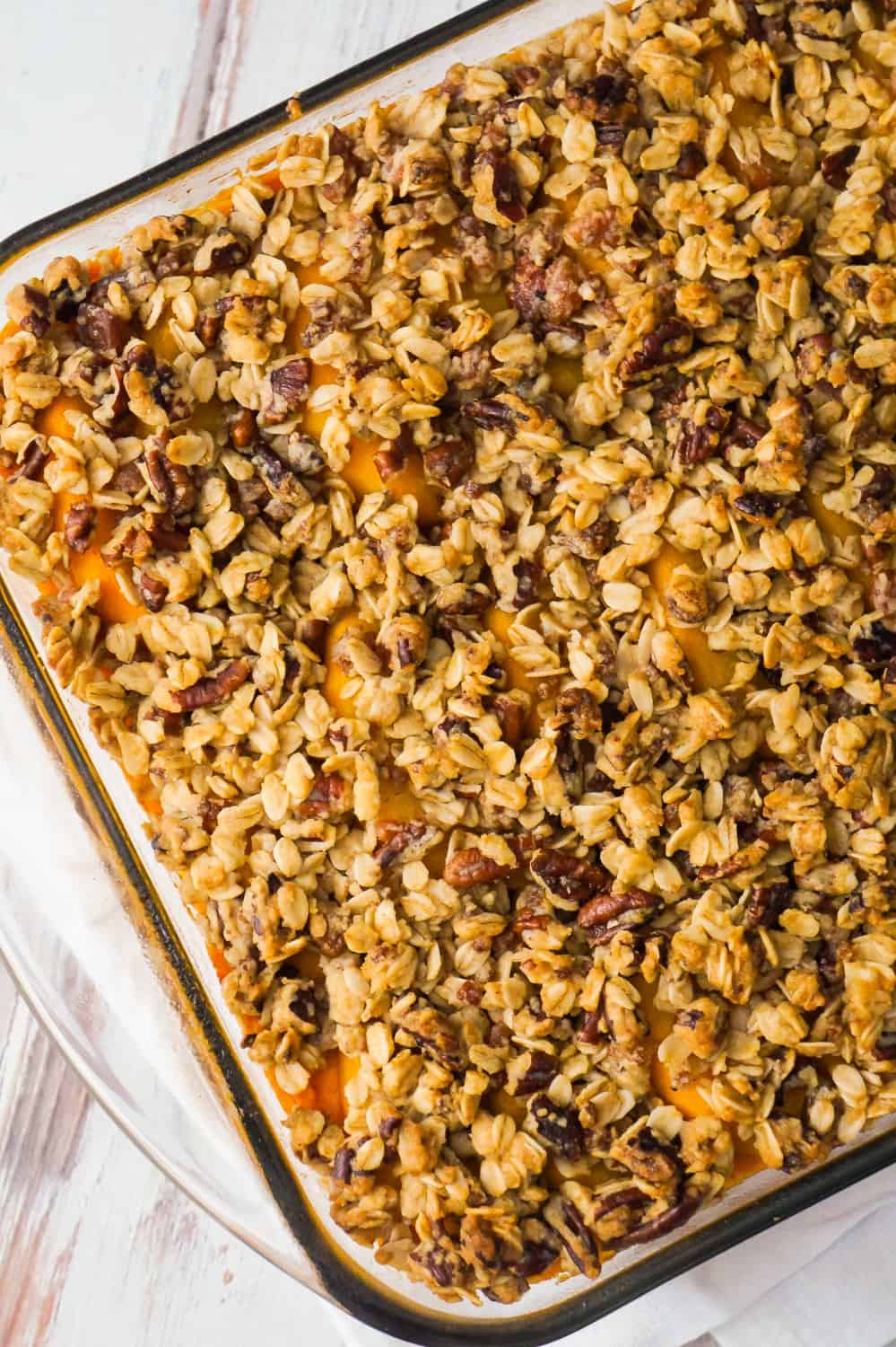 Sweet Potato Casserole with Peaches, Pecans & Bacon is the perfect side dish for a holiday dinner. Creamy mashed sweet potatoes are topped with sliced peaches and an oat crumble with pecans and bacon.