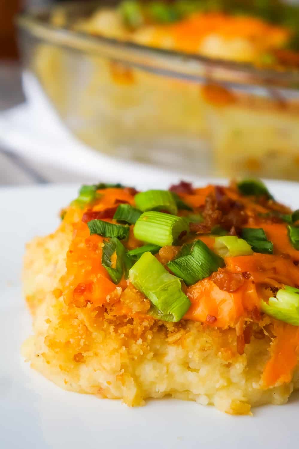 Loaded Mashed Potato Casserole is a hearty side dish recipe perfect for holiday dinners. This mashed potato casserole is loaded with cheddar cheese, bacon, onions and crushed Ritz crackers.