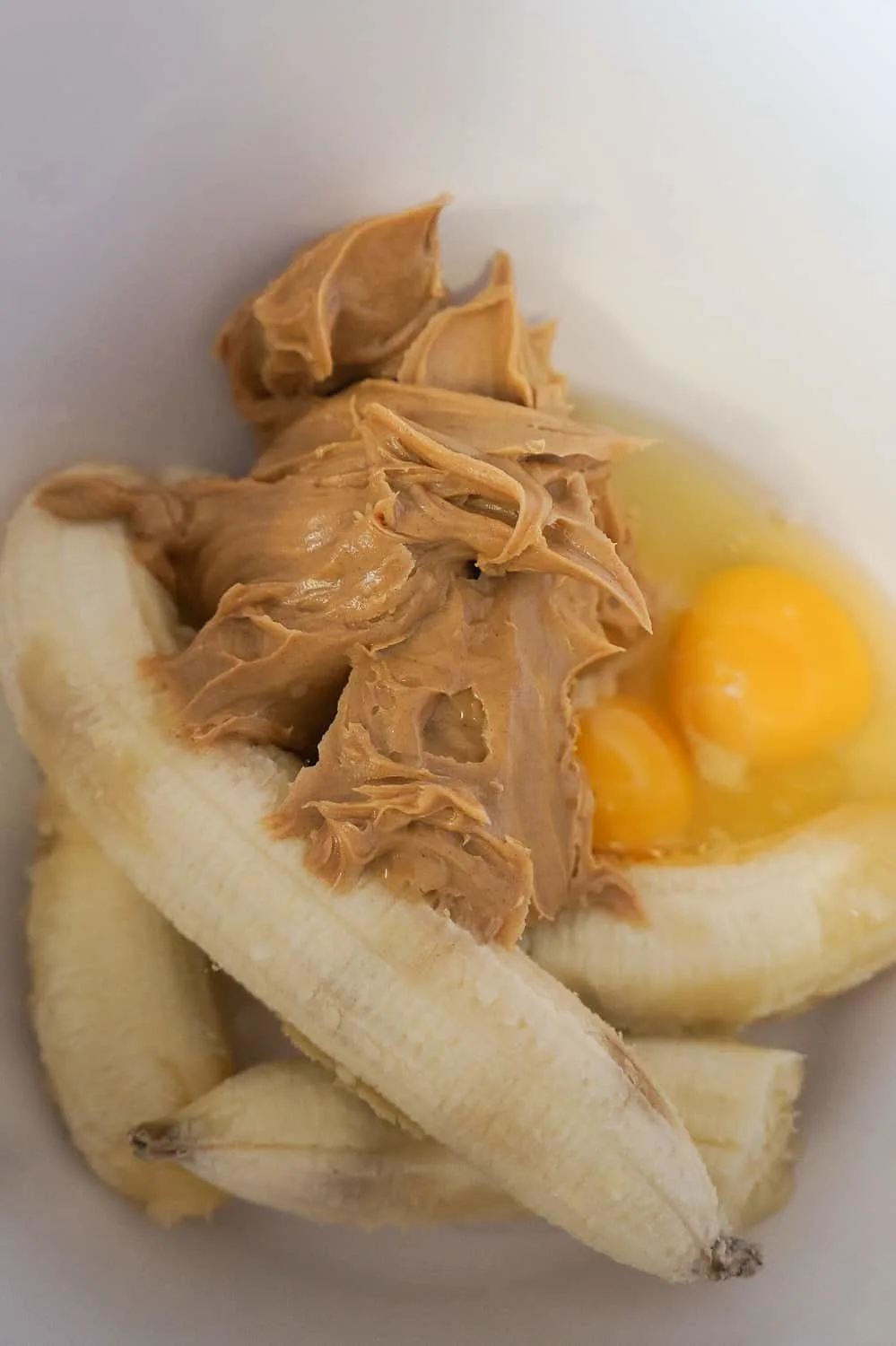 bananas, peanut butter and eggs in a mixing bowl