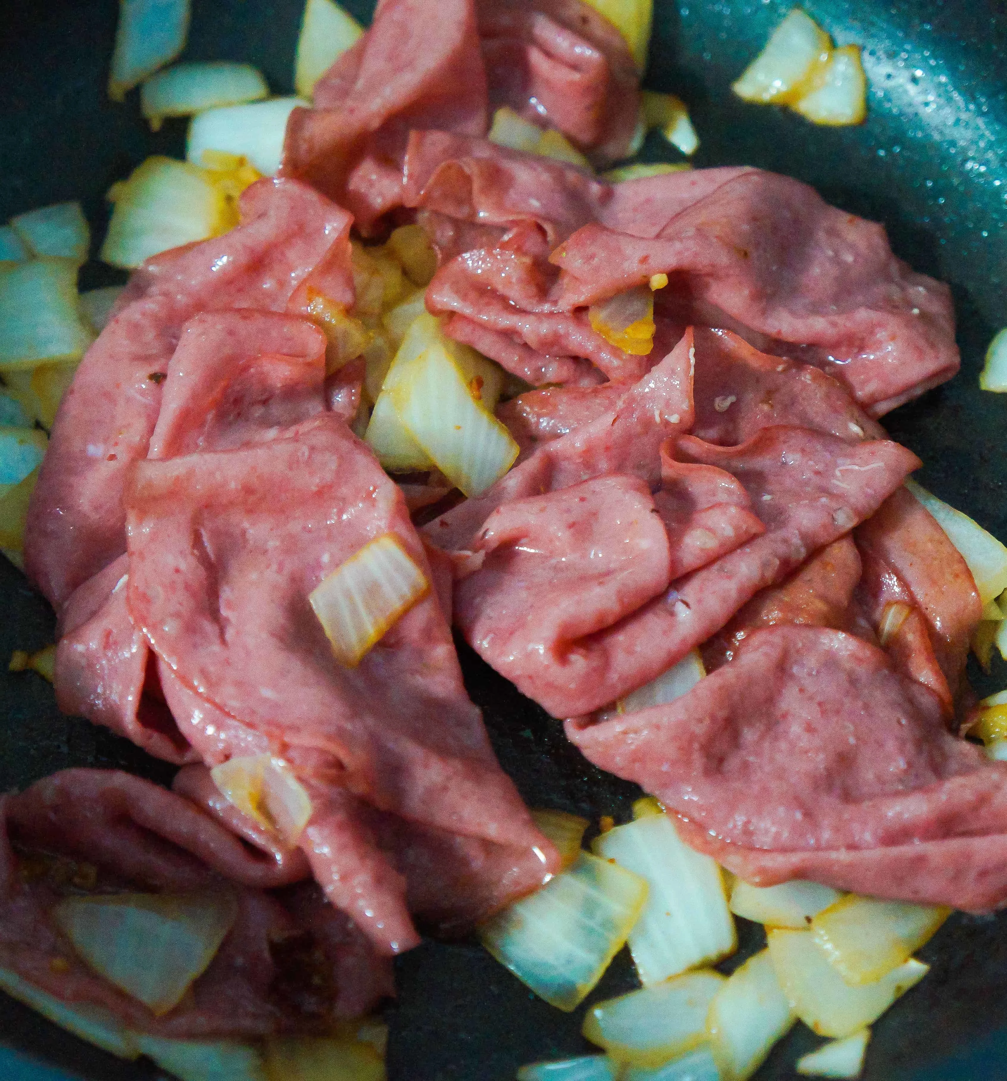 corned beef and sauteed onions in a frying pan